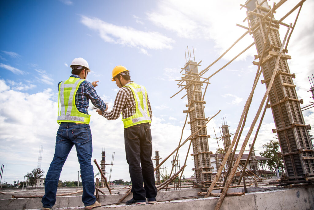 Construction professionals reviewing a tablet at a work site.