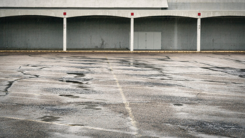 Rain falling across a wet commercial parking lot