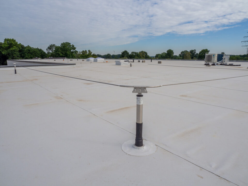 Pipe penetration with a flashing boot on a low-slope membrane roof.