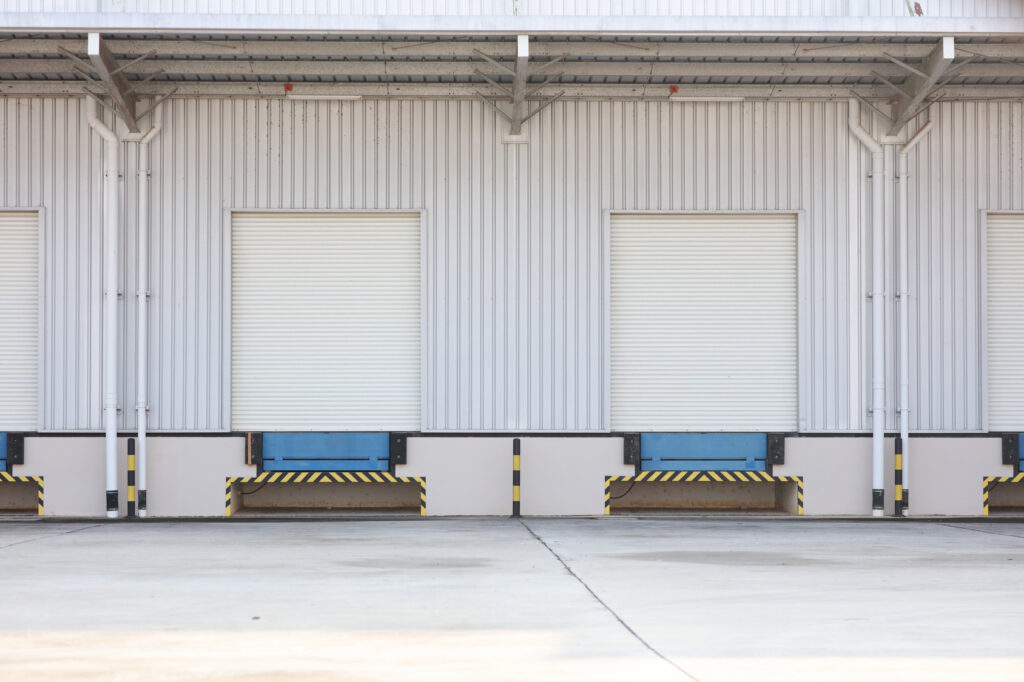Warehouse loading bays with closed dock doors and concrete apron
